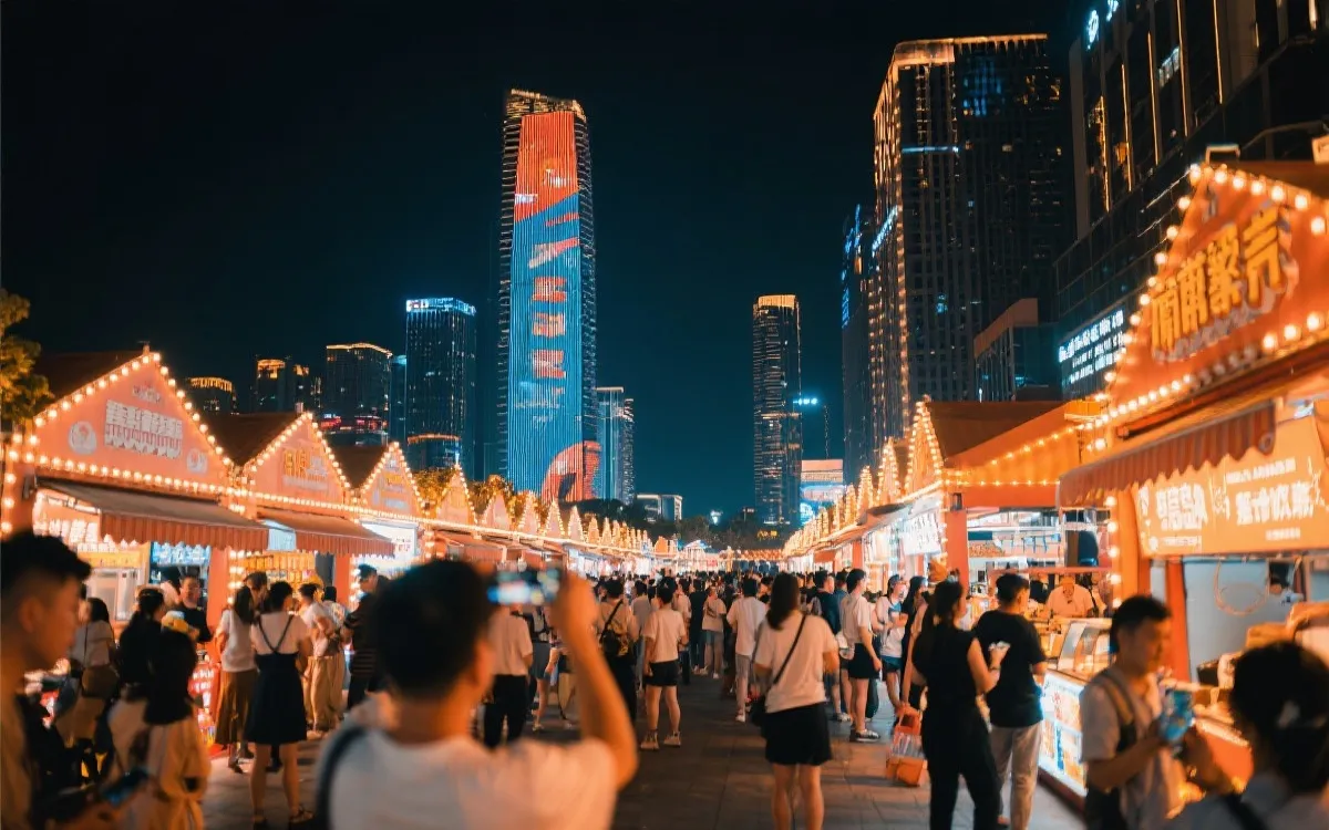 城市地标夜景灯光与夜市街区联动，游客在夜间消费与拍照